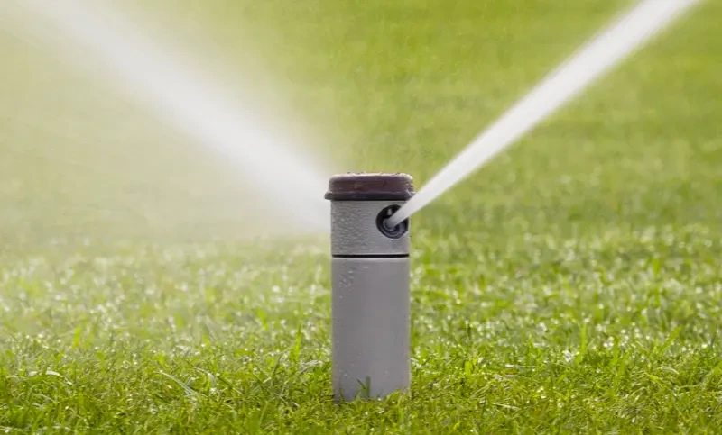 Automatische Sprinkleranlage bewässert Tennisplatz