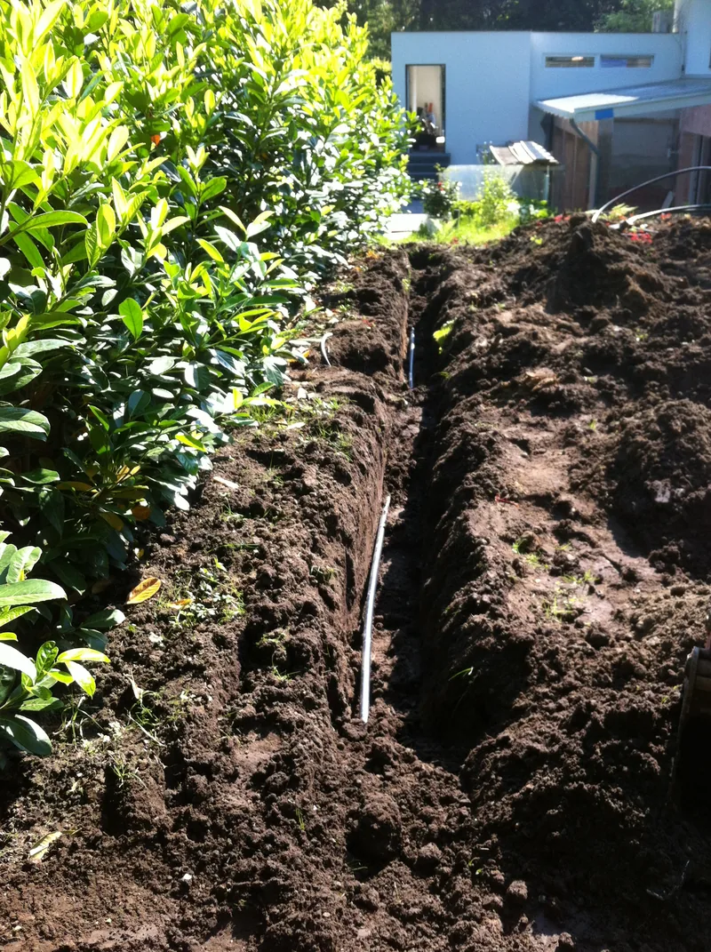 Schmaler, tiefer Graben zwischen Hecke und Rasenfläche