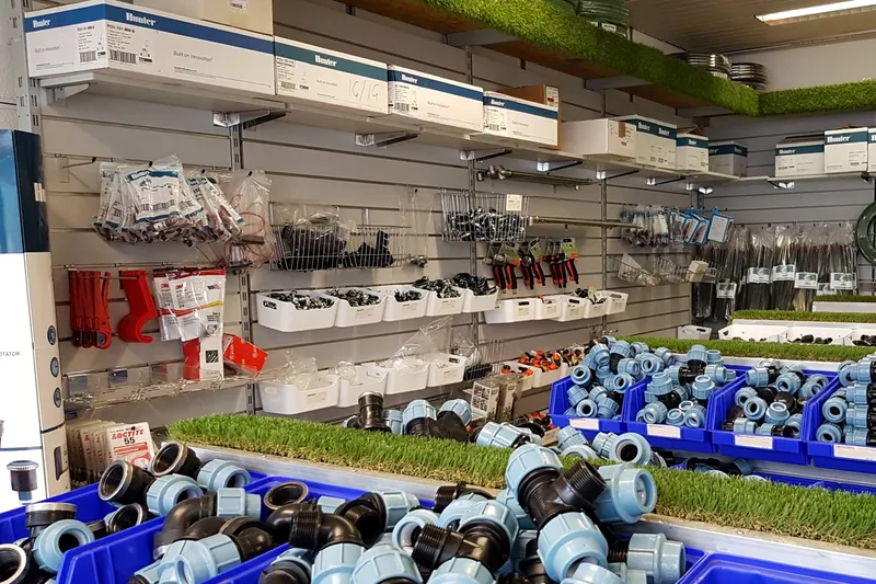Verkaufsraum in Neuss mit PE-Klemmverbindern in blauen Kisten und Regalen voller Hunter-Ersatzteile