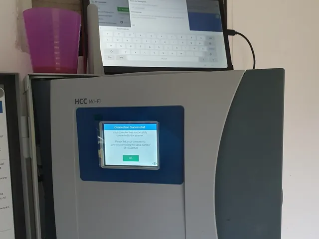 Steuergerät mit WLAN an der Wand, darüber ein Tablet mit der Steuerungs-App